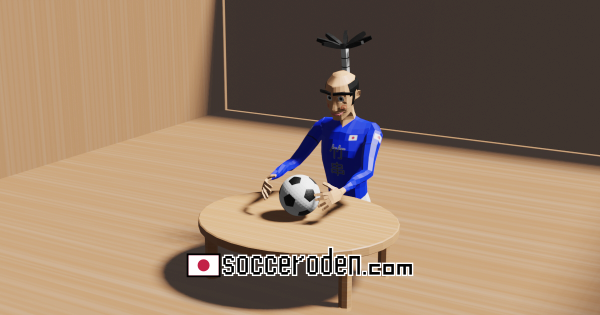 ちゃぶ台の上にあるサッカーボールを見つめる人の画像
